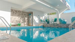 a swimming pool in a house with blue chairs at Villa Rosa Boca Chica in Boca Chica