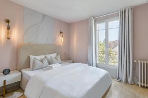 a bedroom with a large white bed and a window at RESIDENCE WAVES Paris Orly Aéroport in Villeneuve-Saint-Georges