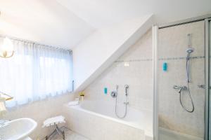 un bagno con doccia, vasca e lavandino di Parkhotel Styria a Steyr