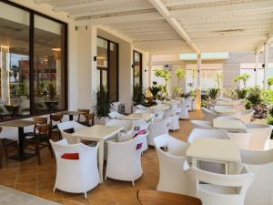 a restaurant with white tables and chairs at Hotel Primus in Shëngjin