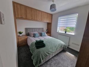 a bedroom with a bed with a green blanket at Urban Retreat in Newcastle- Pet friendly- Garden in Newcastle upon Tyne