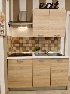 a kitchen with wooden cabinets and a sink at Casa Giannina in Germignaga