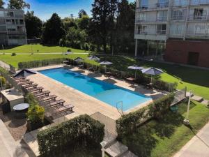 an overhead view of a swimming pool with chairs and umbrellas at iDeal Concord Pilar Aparts in Pilar