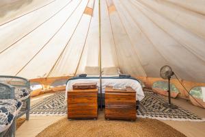 a bedroom with a bed in a tent at Zen Valley Glamping in Plettenberg Bay