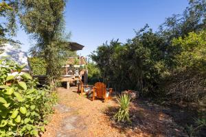 a backyard with a table and chairs and trees at Zen Valley Glamping in Plettenberg Bay +10 photos