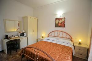 a bedroom with a bed and a desk and a microwave at Affittacamere Agata Levanto in Levanto +3 photos