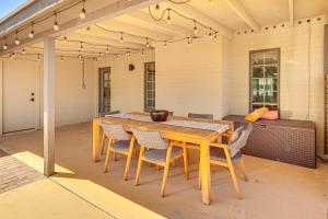 a wooden table and chairs on a patio at 3 Mi to Dtwn Shops and Eats Mesa Home with Pool! in Mesa