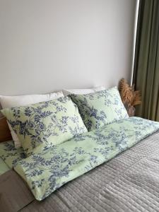 een bed met blauwe en witte kussens erop bij Poilsis Kunigiškiuose in Palanga