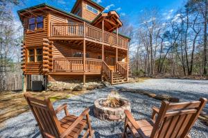 a log cabin with two chairs and a fire pit at Indoor Pool Beauty in Cosby