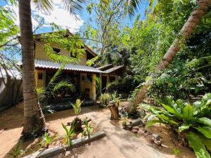 a house in the middle of a forest with palm trees at Vinka Place Arugambay in Arugam Bay