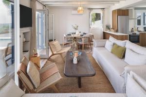a living room with a couch and a table at Villa Astrofegia Moonlit Escape with Sea Views in Pachyammos