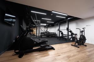 a gym with several treadmills and exercise bikes at Laguna Beskidów Resort - Apartament Miętowy in Zarzecze