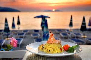 a plate of food on a table near the ocean at Sunny beach Jonufer in Vlorë