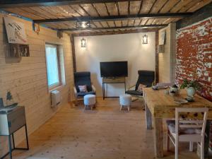 un soggiorno con un tavolo e una televisione di Grotini a Ķipari Altre 13 foto