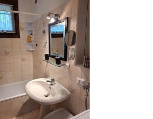 une salle de bains avec lavabo, miroir et baignoire dans l'établissement Villetta singola con giardino Cottage Ghisallo zona Bellagio, à Magreglio 46 autres photos