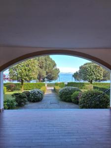 an archway leading to a garden with bushes and trees at Lake's dream in Feriolo