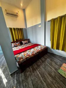 a bedroom with a bed in a room with yellow curtains at The Nature swimming resort in Puducherry
