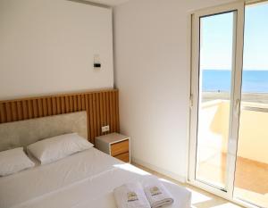 a bedroom with a bed and a view of the ocean at Hotel Primus in Shëngjin +126 photos
