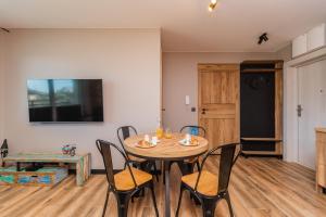ヤンタルにあるFlatbook Apartamenty - Jantar Resort Loftのテーブルと椅子のあるダイニングルーム