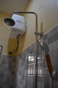 a shower in a bathroom with a fan at Volunteer House in Msaranga