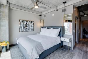 a bedroom with a large bed with white sheets at Sable 501 - Luxury Two Story Loft in Minneapolis +31 photos