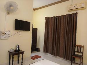 a room with a curtain and a television on the wall at Vang Vieng Camellia Hotel in Vang Vieng