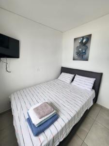 a bedroom with a bed with two towels on it at Premium 2BR Sea View Apartment Bat Yam in Bat Yam
