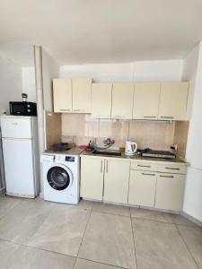 a kitchen with white cabinets and a washing machine at Premium 2BR Sea View Apartment Bat Yam in Bat Yam