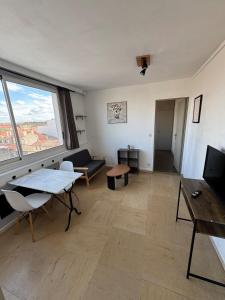 a living room with a table and a large window at Appartement lumineux au coeur de Valence 52 in Valence