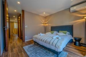 a bedroom with a large bed with a blue headboard at Maison La Fontaine in Gières