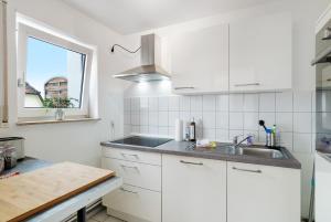 a white kitchen with a sink and a window at Nette kompakte Wohnung mit Balkon in Pforzheim