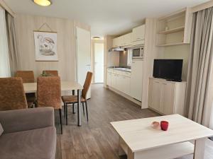 a living room with a kitchen and a dining room at Familie Chalet Oostkapelle OK30 in Oostkapelle