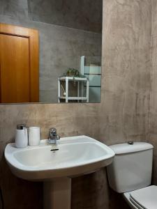 a bathroom with a sink and a toilet and a mirror at El Tiburon in Playa de Gandia +21 photos