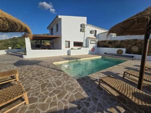 a villa with a swimming pool and a house at Casa Perruchena in Los Romanes