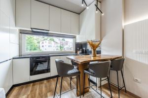 a kitchen with a wooden table and chairs at Chloe's Central Apartment in Durrës