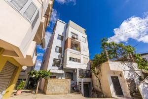 a tall white building in front of some buildings at Chloe's Central Apartment in Durrës
