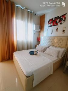 a bedroom with a white bed with a teddy bear on it at Jml'spod Royal in Lapu Lapu City
