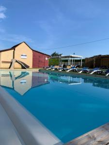 a swimming pool with blue water in front of a building at OPHEA 4 personnes in Limeuil
