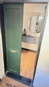 a green door in a room with a mirror at La CASA del PORTO ANTICO in Genoa