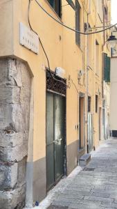 a building with a green door on a street at La CASA del PORTO ANTICO in Genoa