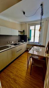 a kitchen with a table and a sink and a window at La CASA del PORTO ANTICO in Genoa