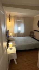 a bedroom with a bed and a table with a lamp at La CASA del PORTO ANTICO in Genoa