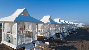 a row of blue and white huts on a beach at Lara Street Hotel in Antalya