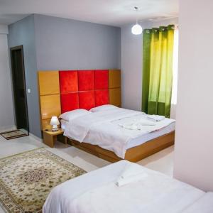 a bedroom with two beds and a colorful wall at Vila Panorama 2 Voskopojë in Voskopojë +5 photos