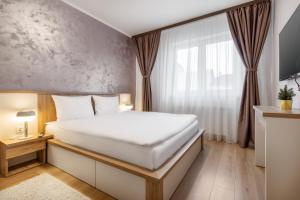 a bedroom with a white bed and a window at Quebec Flat in Oradea