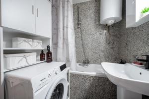 una lavadora blanca en un baño junto a un lavabo en Betula, en Omiš