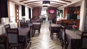 a dining room with tables and chairs in a restaurant at Vila Panorama 2 Voskopojë in Voskopojë