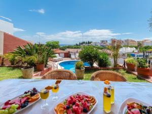 una mesa con una bandeja de fruta y bebidas en Villa Nina Marbella, en Marbella