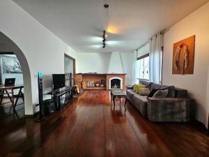 a living room with a couch and a fireplace at Quartos Aconchegantes em Casa Gigante no meio do Brooklin in Sao Paulo
