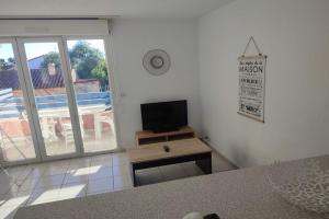 a living room with a flat screen tv on a wall at Très beau T2 - Emeraude 40 in Canet-en-Roussillon